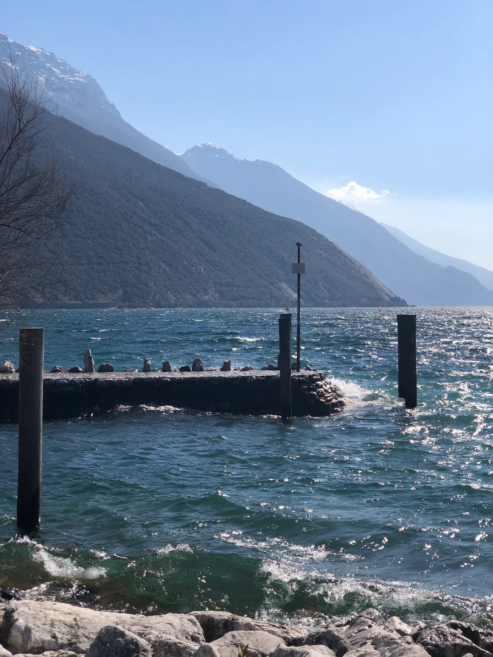 Il molo con le onde e le montagne innevate