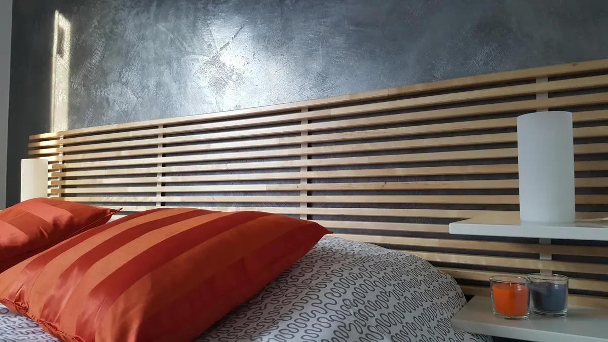 SOLE, la testiera in legno e i cuscini arancio
